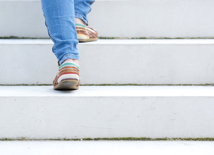 Female walking upstairs on stone staircase outdoors